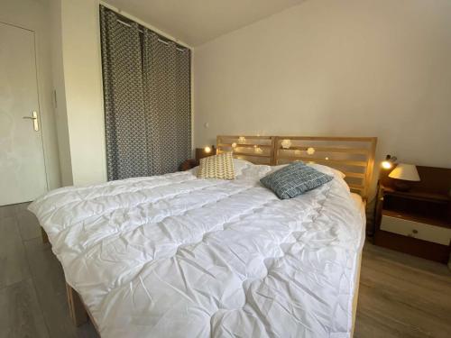 une chambre avec un grand lit blanc avec deux oreillers dans l'établissement Sainte-Maxime, Apt 2 pièces avec piscine, terrasse, parking privé, proche plage et commerces - FR-1-226-487, à Sainte-Maxime