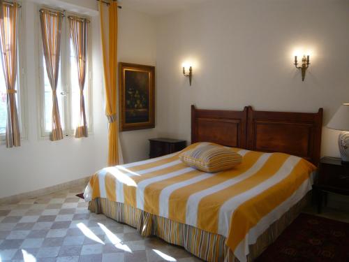 una camera da letto con un letto con una coperta a righe di Auberge de Correns a Correns