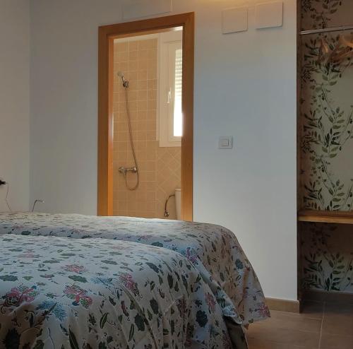 ein Schlafzimmer mit einem Bett und einer Dusche in der Unterkunft La Cultureta in Segura de León