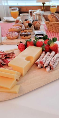 a table topped with cheese and meats and strawberries at Alpina Boutique Hotel Interlaken - Ringgenberg - Adults only ! in Ringgenberg