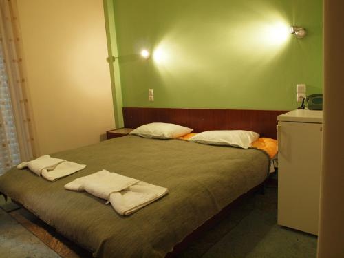 Noufara Hotel في كامينا فورلا: غرفة نوم عليها سرير وفوط
