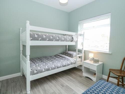a bedroom with two bunk beds and a window at 12 Siesta Mar in Norwich