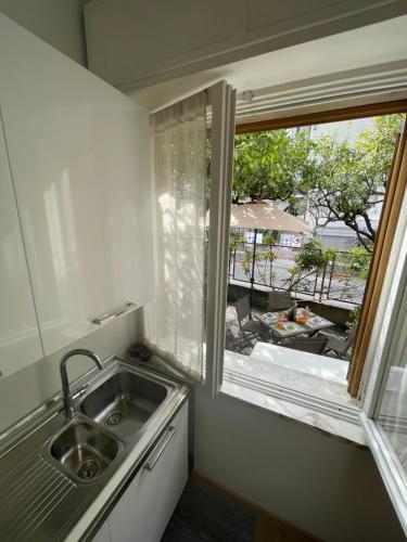 une cuisine avec un évier et une fenêtre dans l'établissement VILLA ROMANA, à Diano Marina
