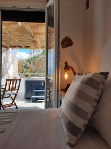 1 dormitorio con 1 cama y puerta corredera de cristal en Janakos Luxury Apartment, en Glinado Naxos