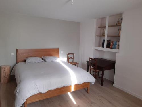 une chambre avec un grand lit blanc et un bureau dans l'établissement Gîte du Bon Pays, à Frontenay