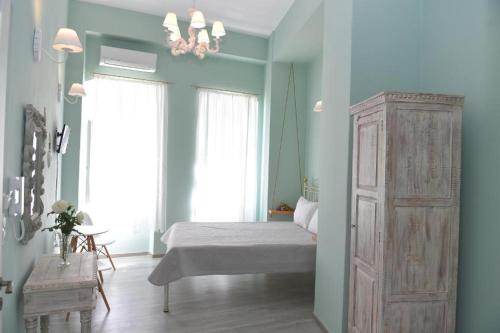 a bedroom with a bed and a chandelier at Oisyra Boutique Suites in Ermoupoli