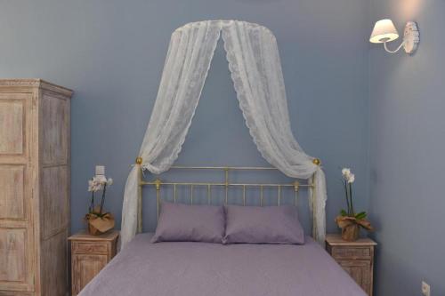 a bedroom with a bed with a canopy and curtains at Oisyra Boutique Suites in Ermoupoli