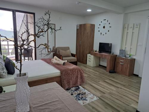 een kamer met een bed, een bank en een tv bij Villa Lucija in Veles