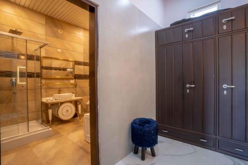 e bagno con doccia, servizi igienici e sgabello. di Luxury Farmhouse Stay, Pure Vegetarian- Santushti Farm, NCR a Tibri