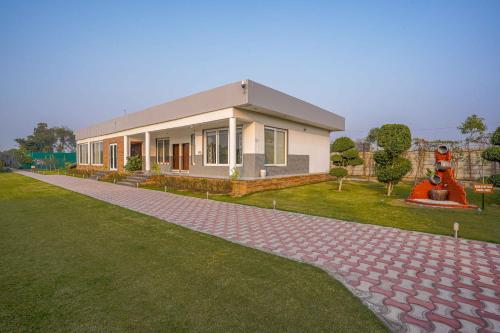 a house with a statue in front of it at Luxury Farmhouse Stay, Pure Vegetarian- Santushti Farm, NCR in Tibri