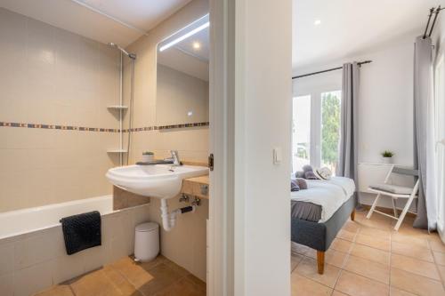 a bathroom with a sink and a bed in a room at El Puerto I 1-3 in Cala D'or