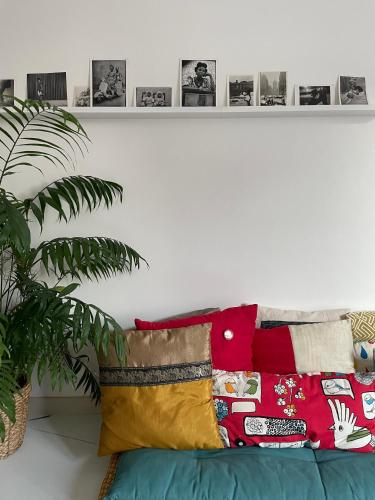 un canapé avec des oreillers et un mur blanc avec des photos dans l'établissement Design Family Appartment in Paris, à Paris