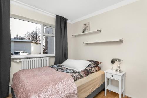 sypialnia z łóżkiem i oknem w obiekcie Cozy and Quiet 2BR Apartment w Reykjavík