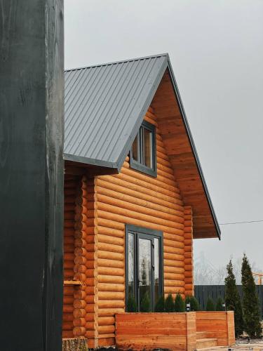 a log cabin with a black roof and a window at Lazni_Kyiv in Kyiv