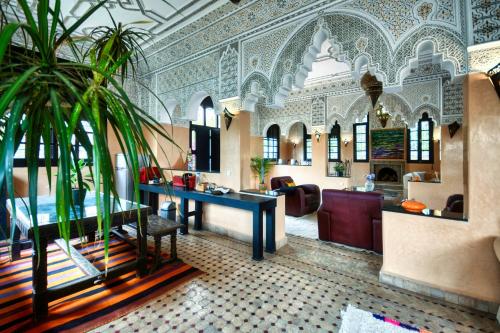 um átrio de hotel com uma mesa e palmeiras em Dafa Splendide Riad Agadir résidentiel 8 or 9 Px em Agadir