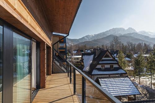 a balcony of a house with mountains in the background at Lipowy Dwór in Zakopane