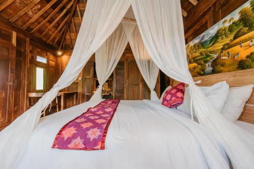 Un dormitorio con una cama blanca con dosel. en Moson Villa Legian, en Legian