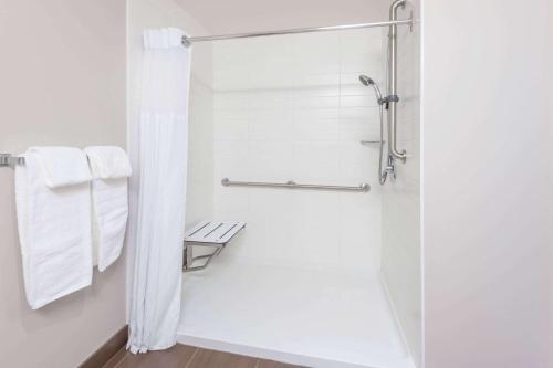 a bathroom with a shower with white towels at Microtel Inn & Suites by Wyndham Fort Saint John in Fort Saint John