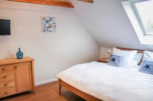 a bedroom with a white bed with blue pillows at Deichkind im Deichhaus in Husum