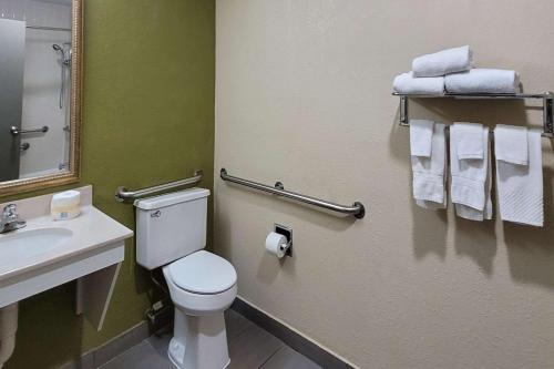 a bathroom with a toilet and a sink and towels at Quality Inn & Suites Columbia I-70 in Columbia