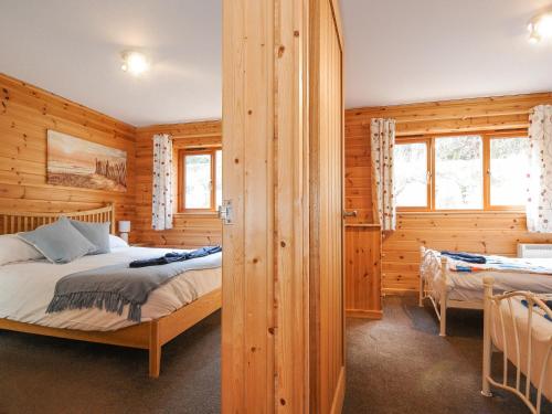 1 dormitorio con 1 cama en una cabaña de madera en Polzeath, en Bodmin