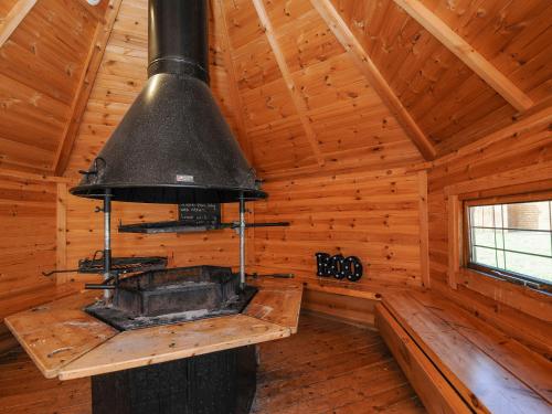 una gran estufa negra en una habitación de madera en una cabaña en Polzeath, en Bodmin