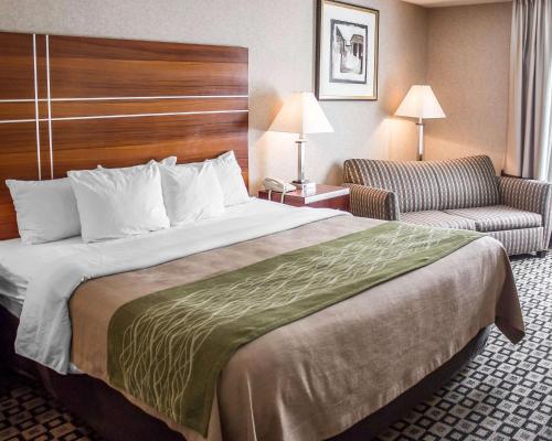 a hotel room with a large bed and a chair at Quality Inn in Clarion