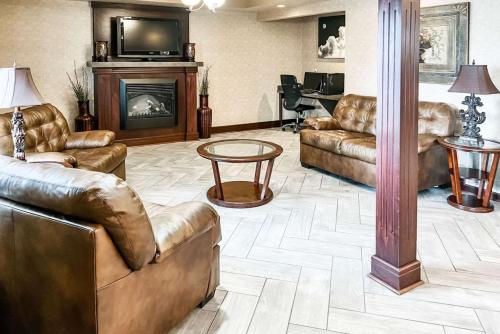 a living room with leather furniture and a fireplace at Quality Inn in Clarion