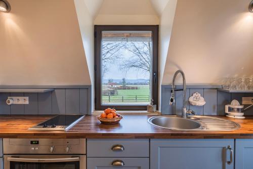 uma cozinha com um lavatório e uma janela em Charmante Chaumière Romantique em Biéville-en-Auge
