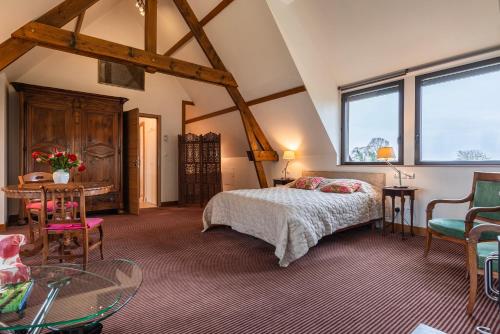 1 dormitorio con 1 cama, mesa y sillas en Charmante Chaumière Romantique en Biéville-en-Auge