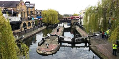 a view of a river with people walking along it at Canal-Side Boutique Apartment in London