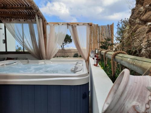 a hot tub in a backyard with a fence at Janakos Luxury Apartment in Glinado Naxos
