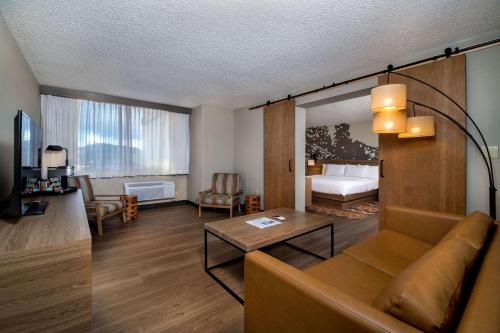 a living room with a couch and a room with a bed at Holiday Inn Estes Park by IHG in Estes Park