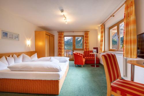 ein Hotelzimmer mit einem Bett und einem Stuhl in der Unterkunft Aparthotel Tyrol in Lermoos