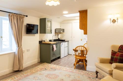 a living room with a kitchen and a table at The Abbey Hotel & Apartments in Bury Saint Edmunds