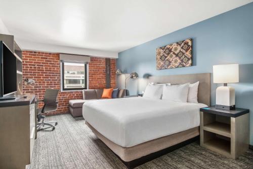 Habitación de hotel con cama grande y sofá en Hyatt House Sacramento-Midtown en Sacramento