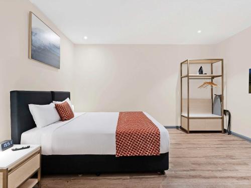 a hotel room with a bed and a dresser at BreakFree on Broadway Sydney, an Accor Hotel in Sydney