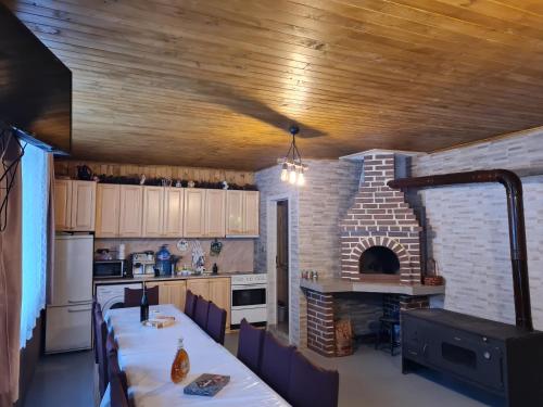 uma cozinha com uma mesa longa e um forno de tijolos em Вила Вайлин em Batak