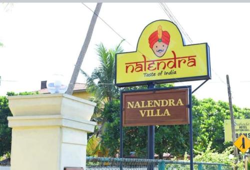 a sign for a restaurant on the side of a street at NALENDRA ROOMS - Oceanfront in Boossa