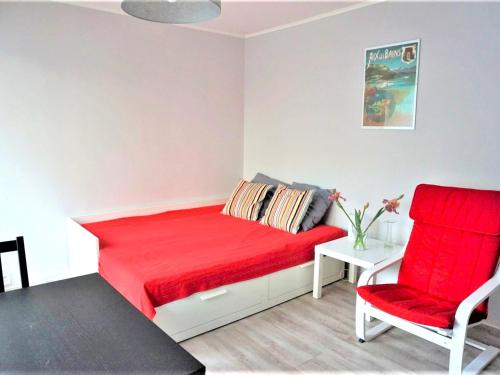 - une chambre avec un lit rouge et deux chaises rouges dans l'établissement Studio moderne à Aix-les-Bains, proche centre-ville et Thermes, avec balcon et fibre optique ! - FR-1-555-37, à Aix-les-Bains