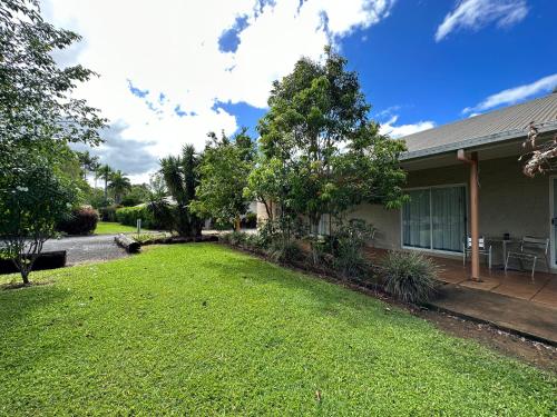 a house with a yard of green grass at Mareeba Motor Inn in Mareeba