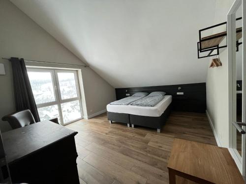 a bedroom with a bed and a desk and a window at Villa Silberberg in Winterberg