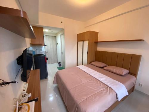 1 dormitorio con 1 cama grande y TV en Apartement Akasa T.K17 By LiviRooms Tangerang, en Ciater-hilir