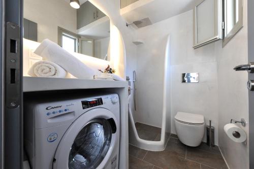 een badkamer met een wasmachine en een toilet bij Droufakos’ home, Lux seafront apartment w. View in Sifnos