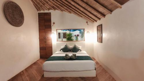 ALOE Beach Villa 1 في Ao Nam Mao: غرفة نوم مع سرير مع دبتين عليه