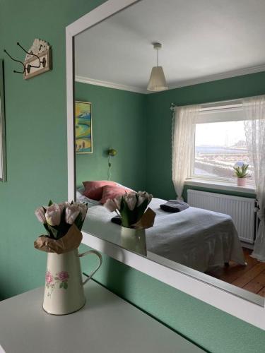 a bedroom with a bed and a large mirror at Guesthouse Hugo in Sørvágur