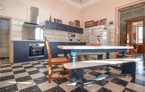 une cuisine avec des armoires bleues et une table et des chaises dans l'établissement 2 Bedroom Beautiful Home In Avignon, à Avignon