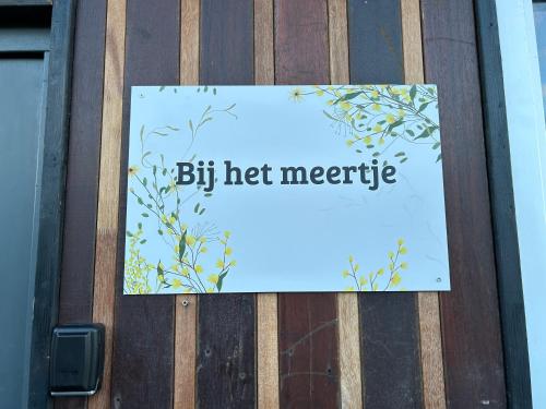 a sign on a wooden door with the words big hot magnetic at Bij het meertje! in Dirkshorn