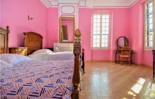 um quarto com paredes cor-de-rosa, uma cama e um espelho. em 2 Bedroom Beautiful Home In Avignon em Avignon