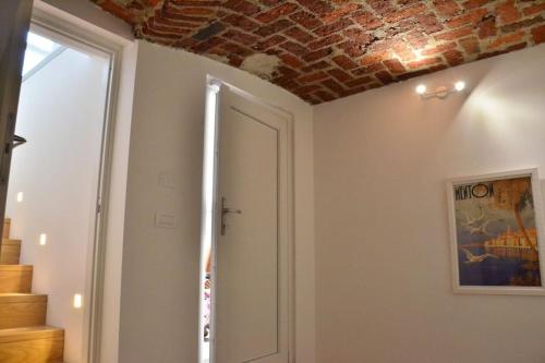 um quarto com um tecto de tijolos e uma porta em Villa di Design con Giardino e Spa in Cittá em Cuneo